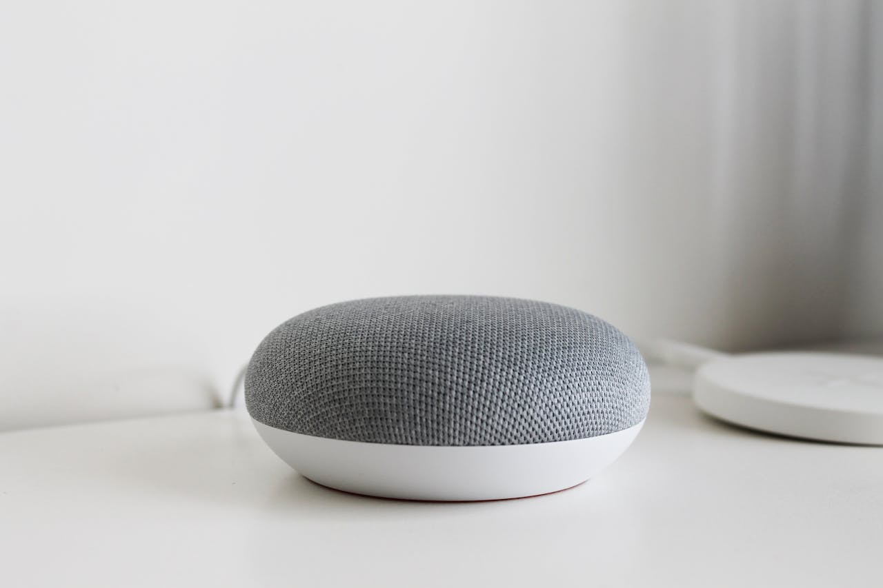 services-01 A sleek and modern smart speaker on a clean white surface, perfect for tech-inspired decor.